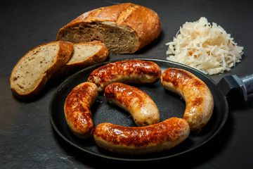 five tasty ruddy juicy sausages fried in large pan
