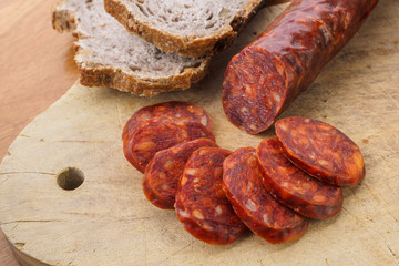 Iberian chorizo, Spanish chorizo ​​or Spanish sausage cut into slices on a wooden board with rustic bread