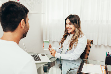 Female sports nutritionist attending patient in her clinic