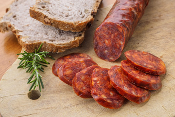 Iberian chorizo, Spanish chorizo ​​or Spanish sausage cut into slices on a wooden board with rustic bread