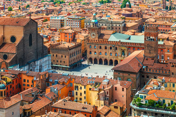 Italy Piazza Maggiore in Bologna old town tower of town hall with big clock and blue sky on background, antique buildings terracotta galleries. - obrazy, fototapety, plakaty