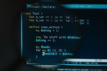 Program code illustrative concept on display screen through magnifying glass