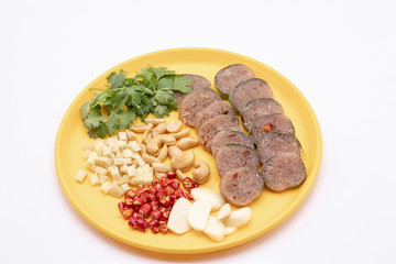 Close up Thai cuisine : Thai sour pork with red chili,ginger,garlic,green coriander and cashews in the yellow dish isolate on white background.