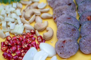 Close up Thai cuisine : Thai sour pork with red chili,ginger,garlic,coriander and cashews in the yellow dish.