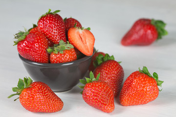 Heap of fresh strawberries in woods on rustic white wooden background 