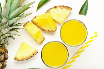 Fototapeta na wymiar Pineapple juice with pineapple pieces and leaves - summer food composition. Refreshing, dietary, organic fruits.