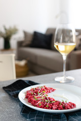 Beetroot risotto selective focus served with glass of white wine, gourmet italian food