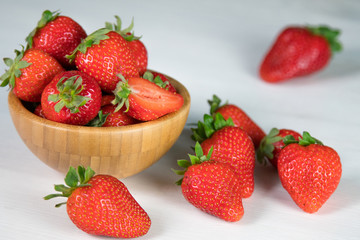 Heap of fresh strawberries in woods on rustic white wooden background 