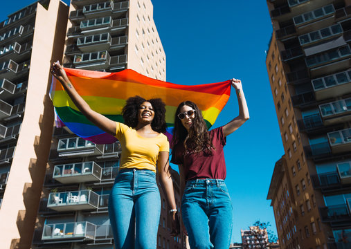 Lesbian couple celebrating with LGBT flag on gay pride day