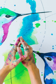 Latin artist painting with watercolor in her studio