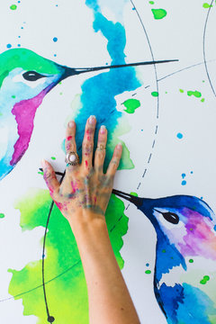Latin artist painting with watercolor in her studio