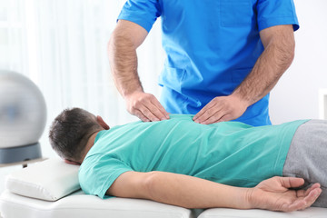Fototapeta premium Doctor working with patient in hospital. Rehabilitation massage