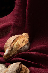 two loaves of bread on the table against the background of colorful burlap,still life,  closeup