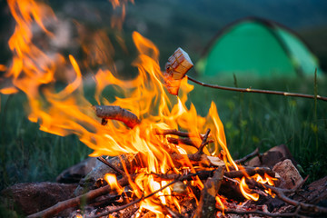 Fried bacon at campfire while camping outdoors.