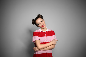 Portrait of beautiful young woman on grey background