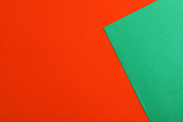 Green and red paper sheets as colorful background, top view