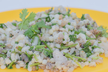 Close up Exotic Thai Food is Spicy Raw Ant Eggs Salad on yellow dish on white background.It is Isan food (Northeastern Thai food)also called Koi Khai Mot Dang.