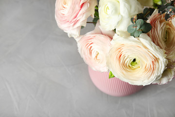 Beautiful spring ranunculus flowers in vase on table, view from above. Space for text