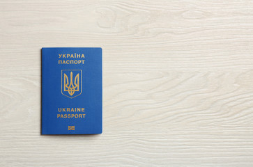 Ukrainian travel passport on wooden background, top view with space for text. International relationships