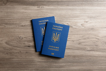 Ukrainian travel passports on wooden background, top view. International relationships