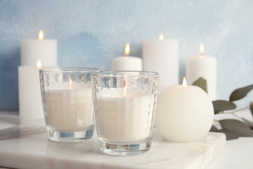 Burning candles on table against color background. Space for text