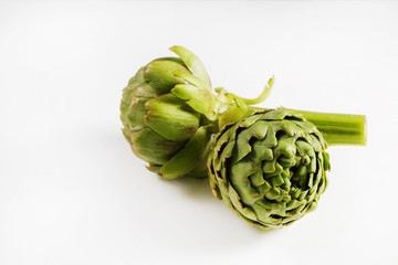 Fototapeta premium Fresh green Italian Artichoke isolated on white background. Organic local produce vegetable. Vegan diet. Clean eating concept. Close up, top view.