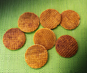 Stroopwafels irrigated spontaneously on a green tablecloth