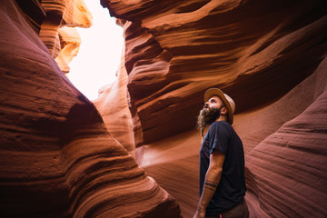 Side view of bearded male examining amazing walls of wonderful ravine during travel through West Coast of USA