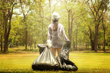 Recycle waste litter rubbish garbage trash junk clean training. Nature cleaning, volunteer ecology green concept. Young woman pick up spring forest at sunset © natamata