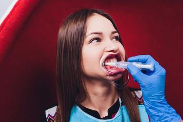 Dentist curing female patient Woman teeth examined at dentists teeth whitening. stomatology office...