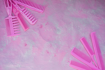 Pink bright comb for hairdressers. Beauty saloon. Tools for hairstyles. Pink background. Barbershop. Set of different hairbrushes. Space for text.