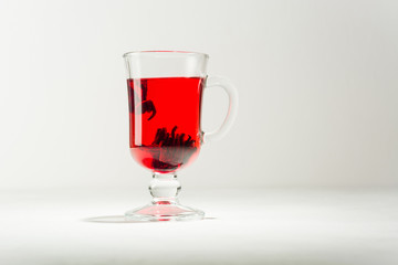 Transparent glass Cup with hot red tea from hibiscus or hibiscus.