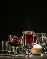 Transparent glass Cup with hot red tea from hibiscus or hibiscus. Glassware and dry petals with sugar.