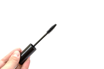 black mascara in hand on white background close up