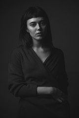 Young woman posing in studio. Black and white. Low key