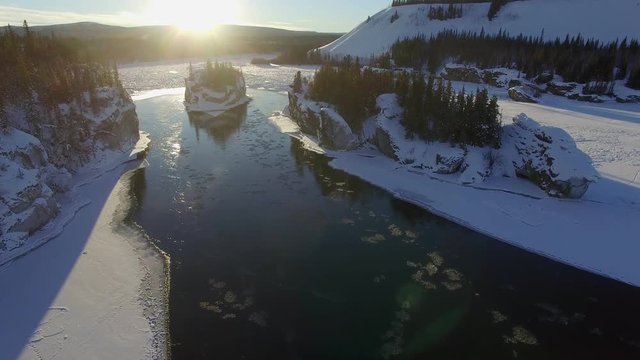 aerial video of yukon river near the area of five finger rapids Yukon in winter with the sun on the horizon