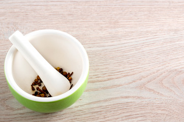 Ceramic mortar and pestle on wooden table