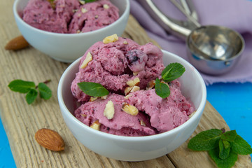 Ice cream with berries. Ice cream balls in a white bowl with nuts and mint.