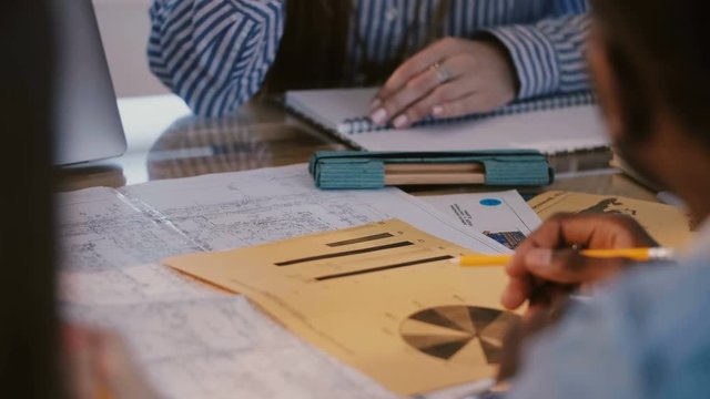 Close-up multiethnic financial company colleagues discussing work project at office table, woman boss giving directions.