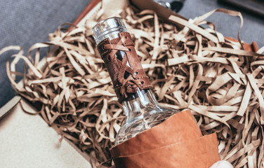 glass bottle in leather case, handmade gift wrapping.