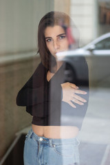 Portrait of a beautiful and sexy girl looking through a window