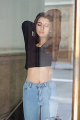 Fototapeta na wymiar Portrait of a beautiful and sexy girl looking through a window