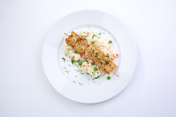 chicken kebab with rice and vegetables on the white background