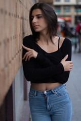 Hipster beautiful girl wearing blank t-shirt and jeans posing against rough street wall, minimalist urban clothing style, mockup for tshirt