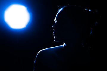 Girl on the night out. Blue, fluorescent color of the light in the club