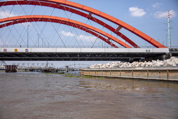 Obraz premium Barge under bridge along Saigon River in Vietnam