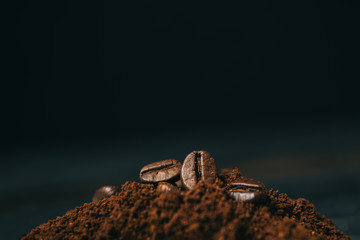 Preparing coffee close up. Roasted coffee beans on freshly ground coffee