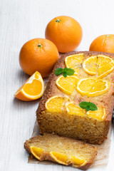 Fototapeta na wymiar Homemade orange syrup cake on white wooden table
