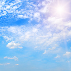 Obraz premium Bright sun on blue sky with white clouds.