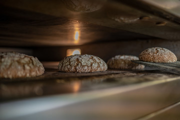 Vom Bäckers Schaufel das heiße Brot aus dem Ofen nehmen